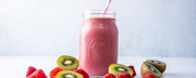 A vibrant pink smoothie in a glass jar with a striped straw, surrounded by fresh kiwi slices and raspberries, highlighting a refreshing, nutrient-rich drink for health and wellness - wenatal favorite recipes for pregnancy and postpartum
